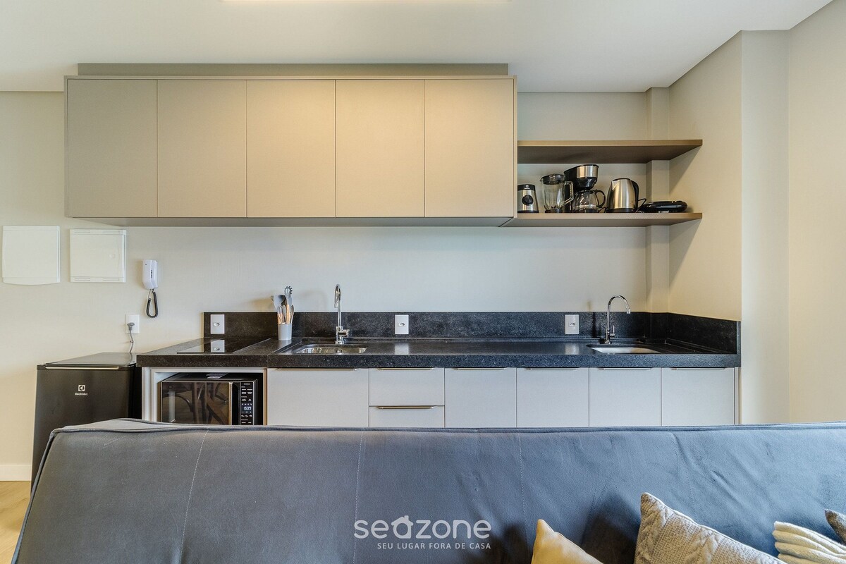 A modern kitchen with a built-in oven, microwave, and coffee maker.