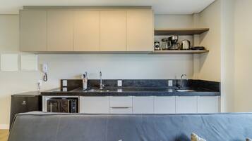A modern kitchen with a built-in oven, microwave, and coffee maker.