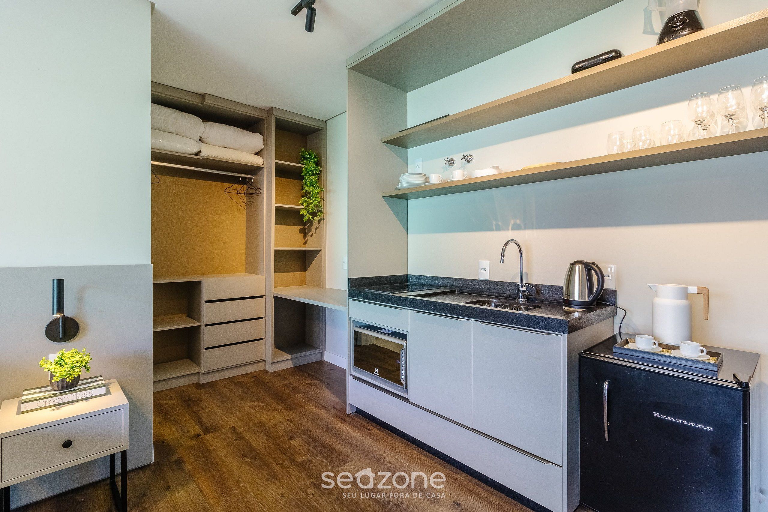 A modern kitchen with built-in appliances, a coffee machine, and a refrigerator.