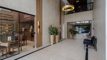 A modern interior with a café, seating area, and a staircase.