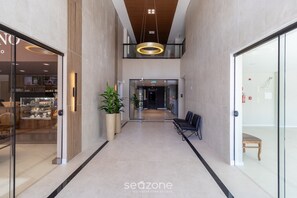 A modern interior with a central corridor, seating area, and glass doors leading to a restaurant. - Your Perfect Stay in Urubici Starts Here! CZZ (Urubici)