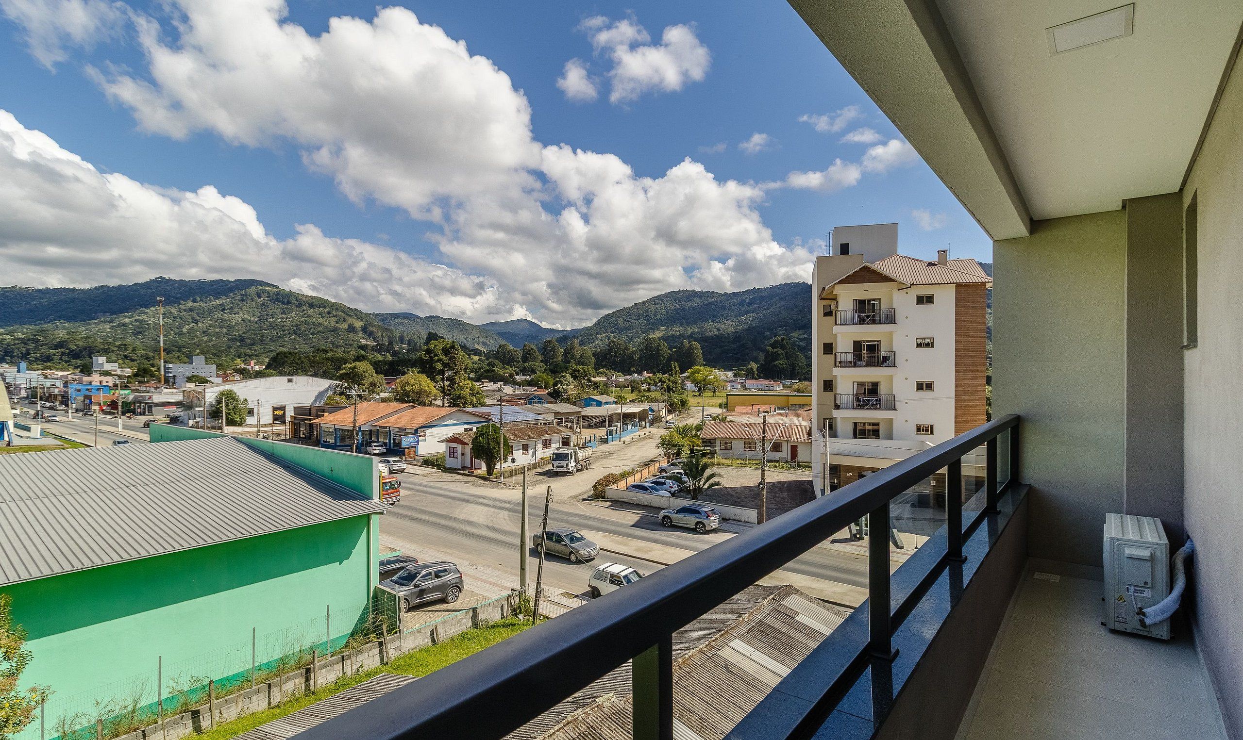A balcony with a view of a town and mountains.