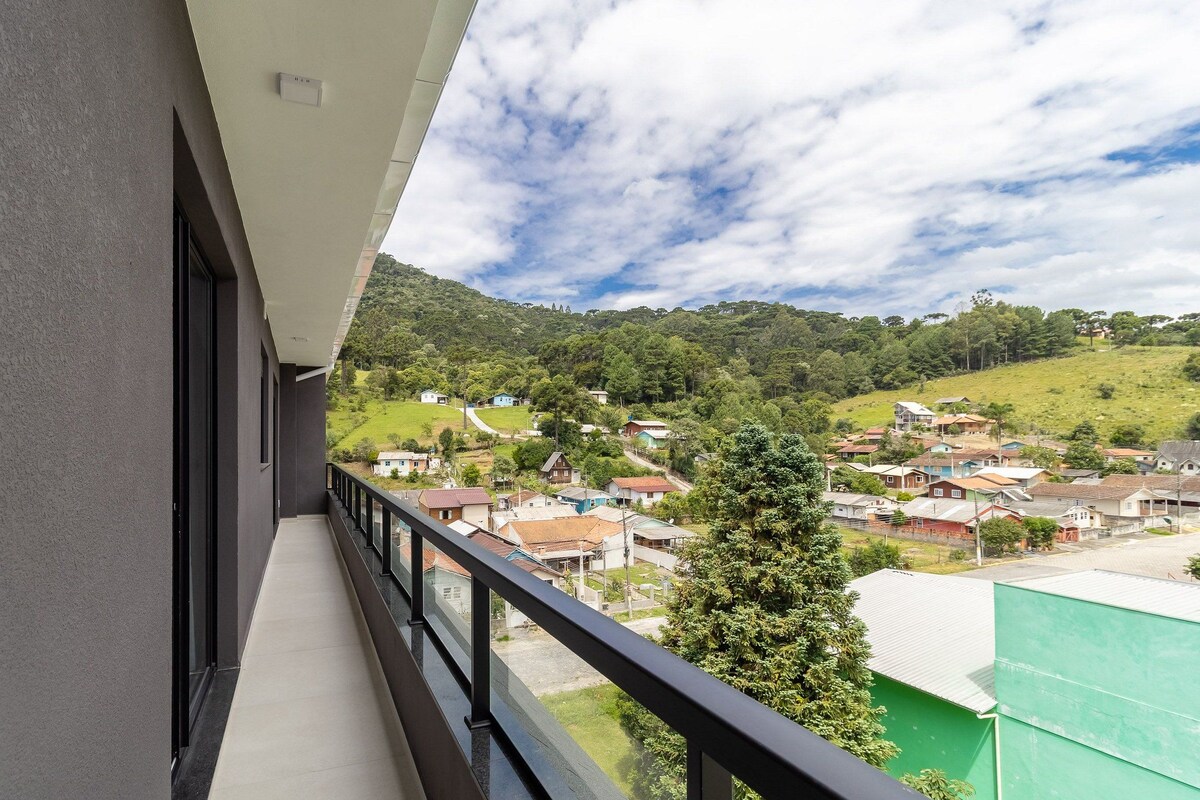 A balcony with a view of a hillside village.