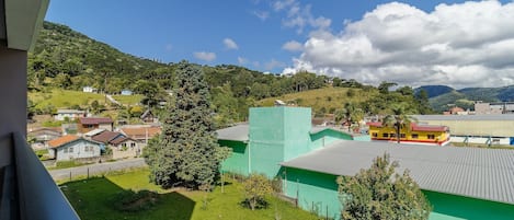 Ett bostadsområde med hus, en grön byggnad och en kulle i bakgrunden.