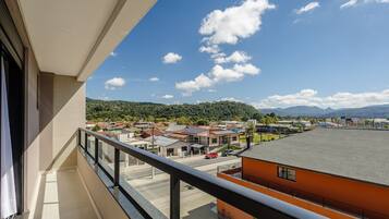 Ein Balkon mit freiem Blick auf eine Stadt, einschließlich Gebäude und einer hügeligen Landschaft im Hintergrund.
