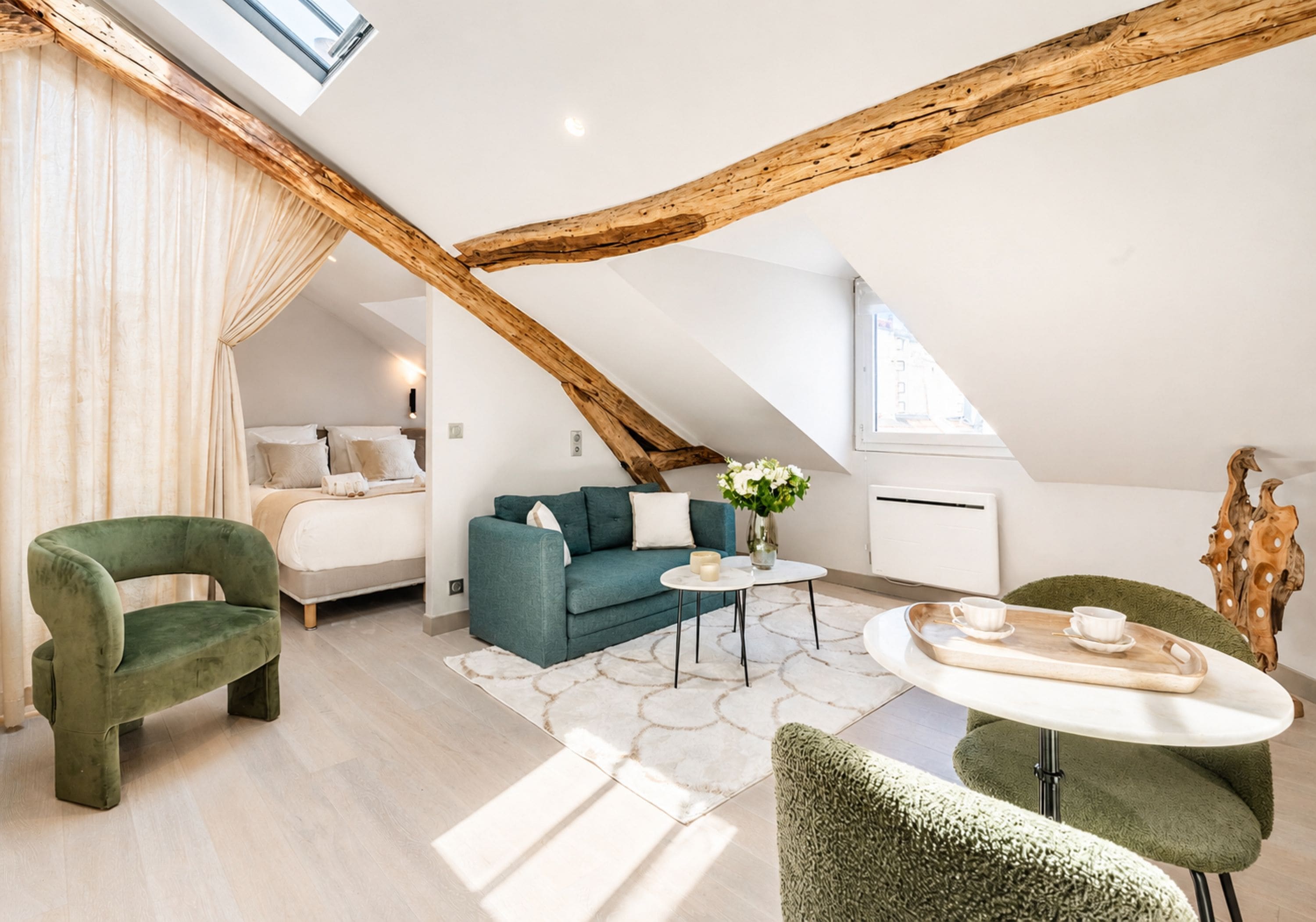 Un dormitorio estilo loft moderno con techo inclinado, un sofá, una mesa de centro y un sillón verde.