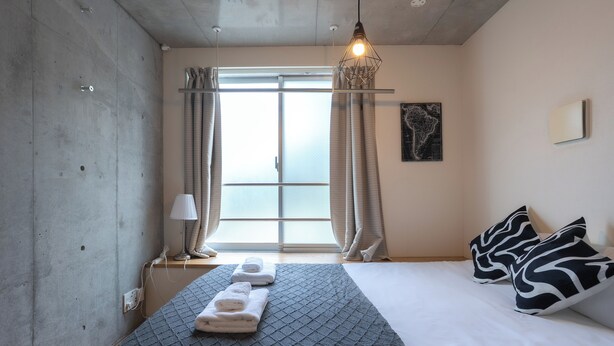 A modern hotel room with a large bed, a hanging light fixture, a window with curtains, and a map on the wall. - Fare Metallo Hote 1-Doube bedroom 202 , Nakano City, Near Shinjyuku (Nakano City)