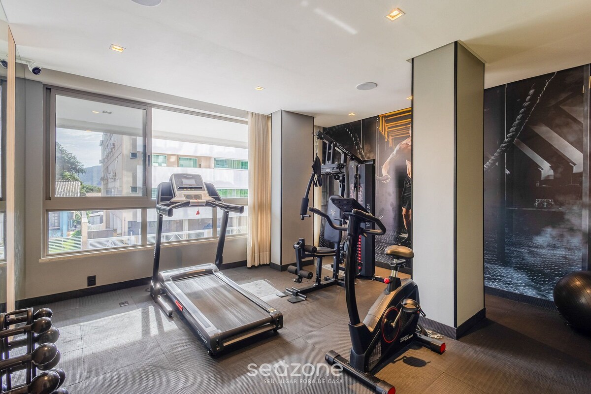 Un gimnasio con cintas de correr, elípticas y pesas libres.