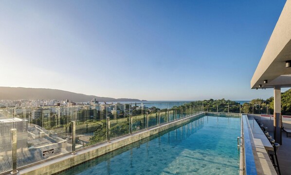 A rooftop infinity pool with a clear view of the city and sea. - Your Exclusive Stay With Pool and Jacuzzi Just 500 Meters From the Beach - ELF (Bombinhas)