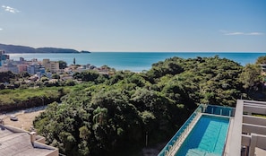 Un quartier résidentiel doté d’une piscine, d’une végétation luxuriante et offrant une vue sur la mer.
