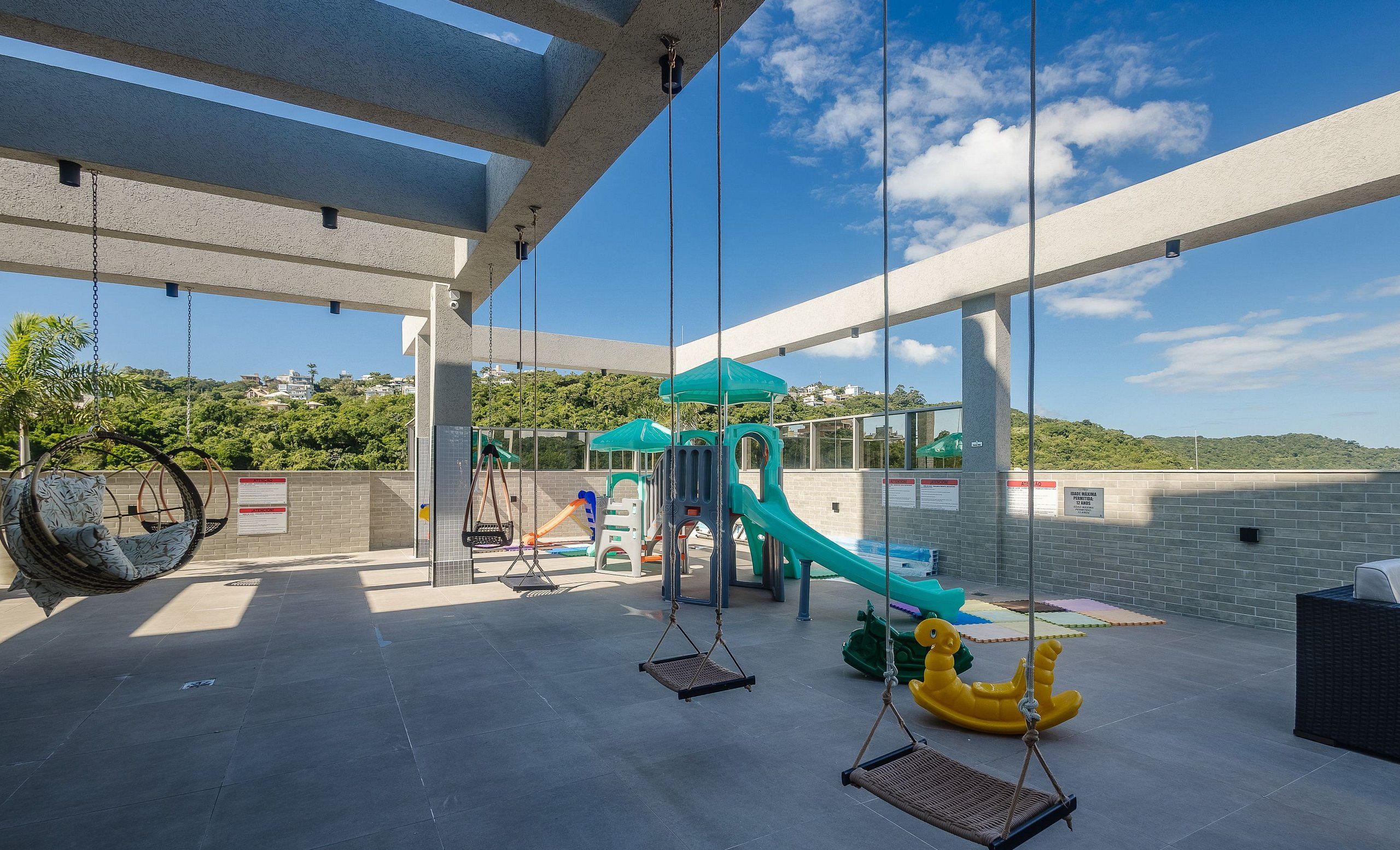 A rooftop playground with swings, slides, and a climbing structure.
