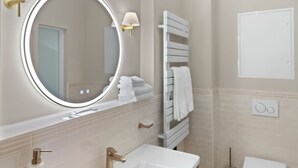 A bathroom with a white sink, a round mirror, a towel rack, and a toilet. - Balcony apartment 12 Korn (Unknown)