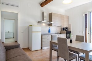 Une cuisine moderne avec un coin repas comprenant un canapé, une table et des chaises.