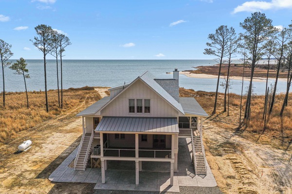With the shoreline unfurling just beyond the steps, this rear view of the home reveals its most breathtaking asset: uninterrupted views of the Chesapeake Bay. From the moment you step outside, you're greeted by salt-kissed air.