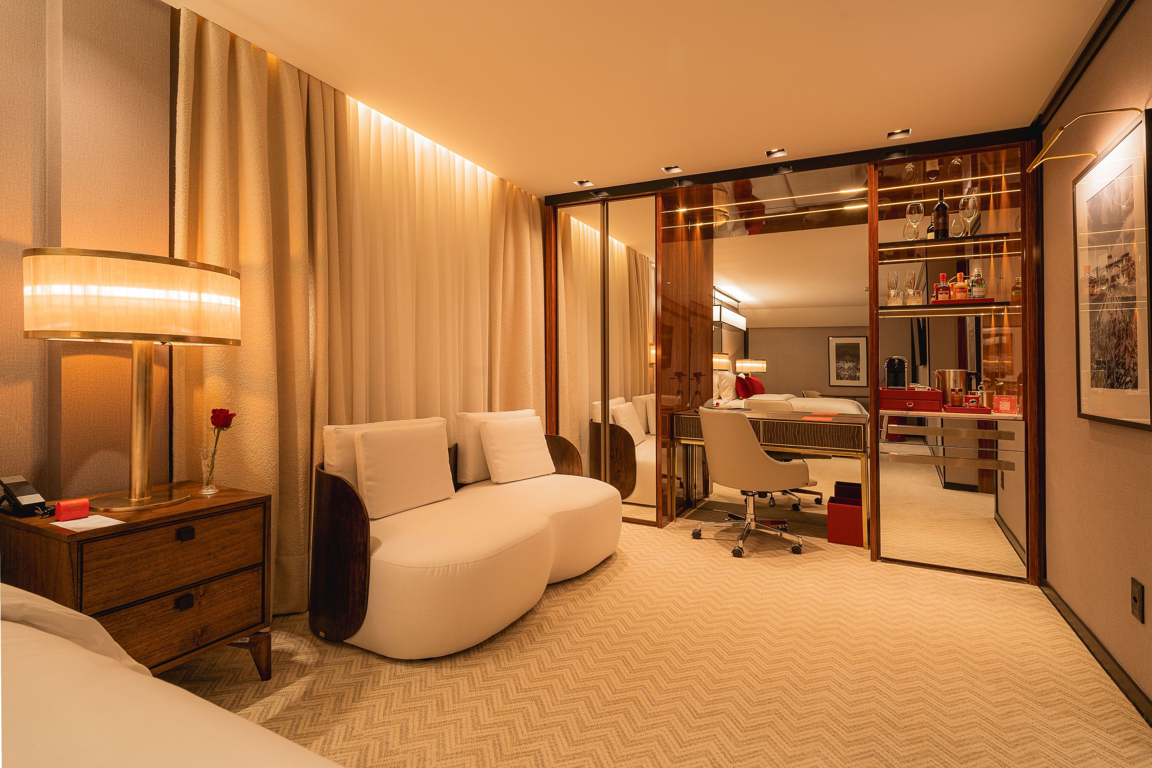 Une chambre d’hôtel comprenant un lit, un bureau, une chaise, un miroir et une armoire.