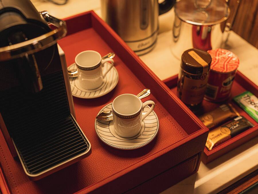 A tray with two cups and a coffee pot, suggesting a coffee service setup.