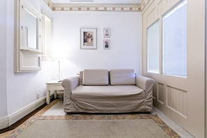 A small, neatly arranged bedroom with a single bed, a nightstand, a lamp, and a window with blinds. - Charmosos Studios no IL Campanario Villaggio Resort ILCJR II (Florianópolis)