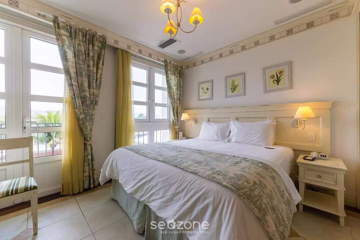 A bedroom with a bed, bedside tables, a chair, and a window with curtains.