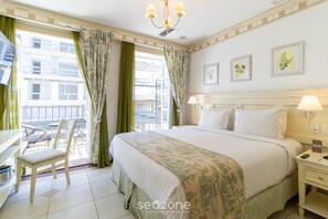 A hotel room with a bed, a desk, a chair, and a balcony with curtains. - Charmosos Studios no IL Campanario Villaggio Resort ILCJR II (Florianópolis)