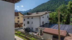 A residential area with buildings, a car, and a mountain backdrop. - GuestHost - Cozy Apartment with Terrace - Tarvisio (Tarvisio)