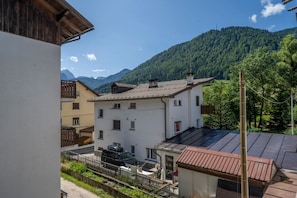 Zona residencial con edificios, un automóvil y montañas al fondo.