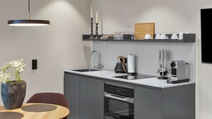 Eine moderne Küche mit Einbauofen, Kaffeemaschine und Spüle.