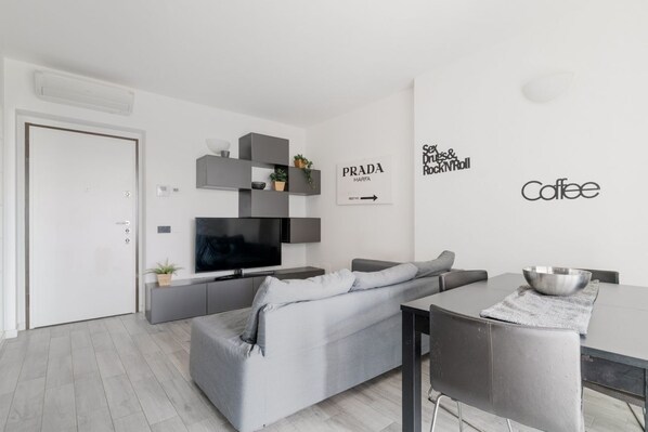 Living area - Cozy 50m2 apartment with balcony, located on the seventh floor of a building with a lift, in a residential context surrounded by greenery.The area is very quiet and well connected thanks to local public transport: a 10-minute walk away is the M1 Rossa B (Milano)
