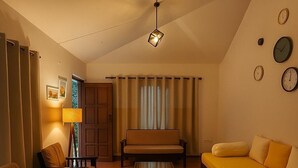 Un salon avec un canapé, des fauteuils, une table basse et une lampe.