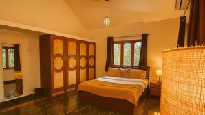 Une chambre à coucher avec un grand lit, une armoire, une fenêtre avec des rideaux et un luminaire suspendu.