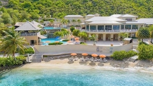 Un resort con una piscina grande, varias edificaciones y una zona de playa.