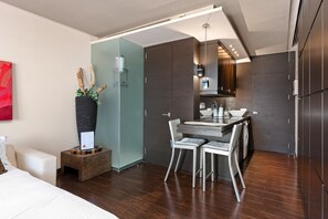 A modern hotel room with a bed, a small dining area, a kitchen, and a bathroom. - Apartment 'Con Vistas Al Mar' with Sea View, Wi-Fi and Air Conditioning (Marbella)