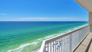 A balcony with a view of the ocean and beach.