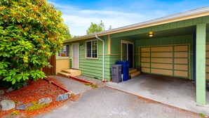 Une maison de plain-pied avec un garage, une véranda et un jardin bien entretenu.