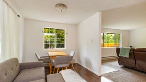 Un salon comprenant un canapé, une table à manger avec des chaises et un divan en cuir marron.