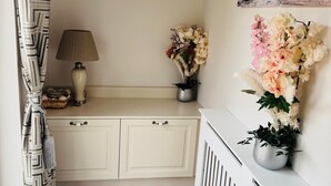 A room with a white cabinet, a lamp, and a wall-mounted painting. - Charming 2-bedroom cottage nea Maynooth University with WiFi (Maynooth)