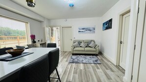 A modern living room with a dining area, a sofa, and a coffee table. - Charming 2-bedroom cottage nea Maynooth University with WiFi (Maynooth)