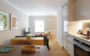A modern kitchen with a dining area, a TV, and a window. - Native Bank (London)
