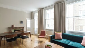 A living room with a dining table, chairs, a sofa, and a coffee table. - Native Bank (London)