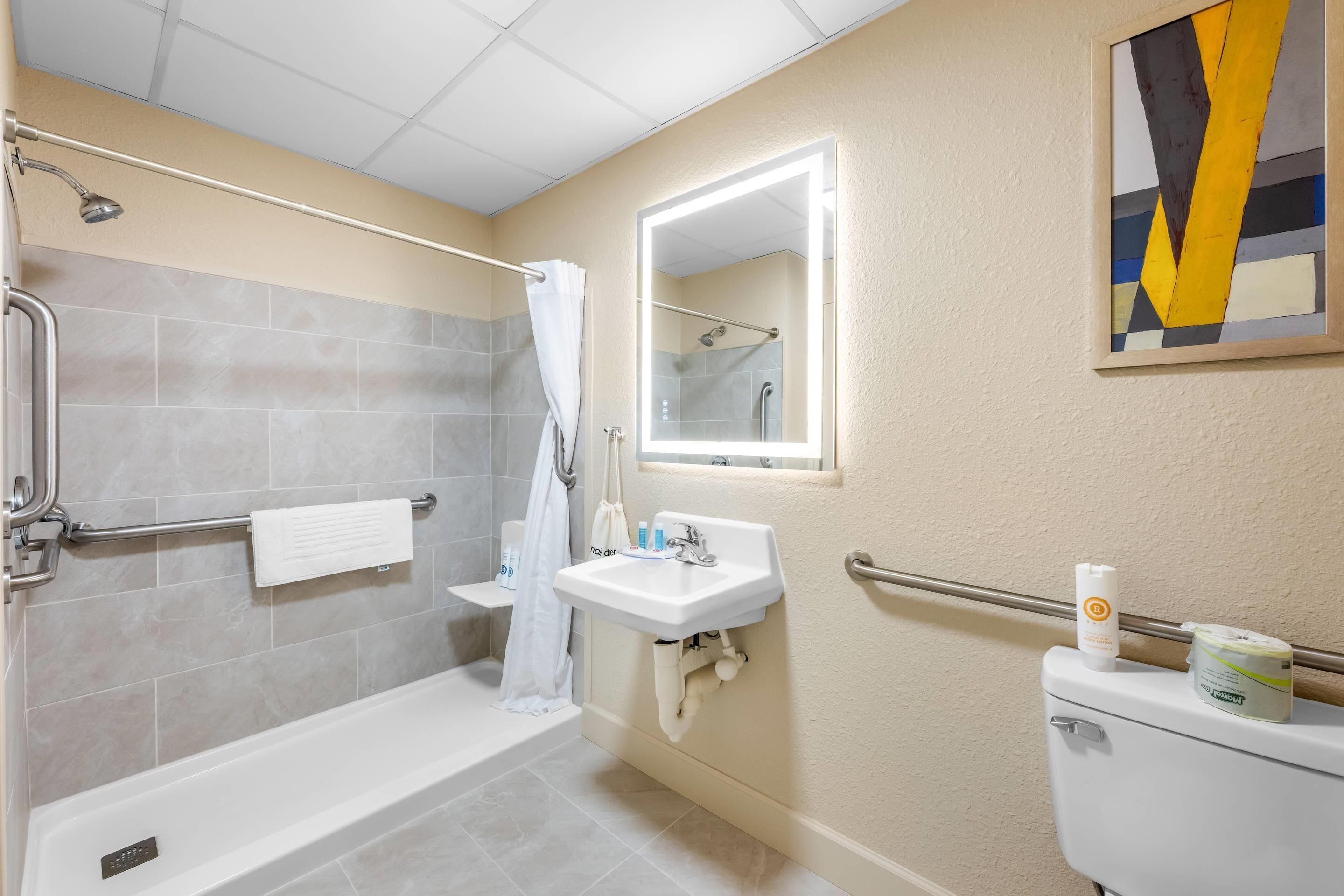 A bathroom with a bathtub, shower, sink, and toilet.