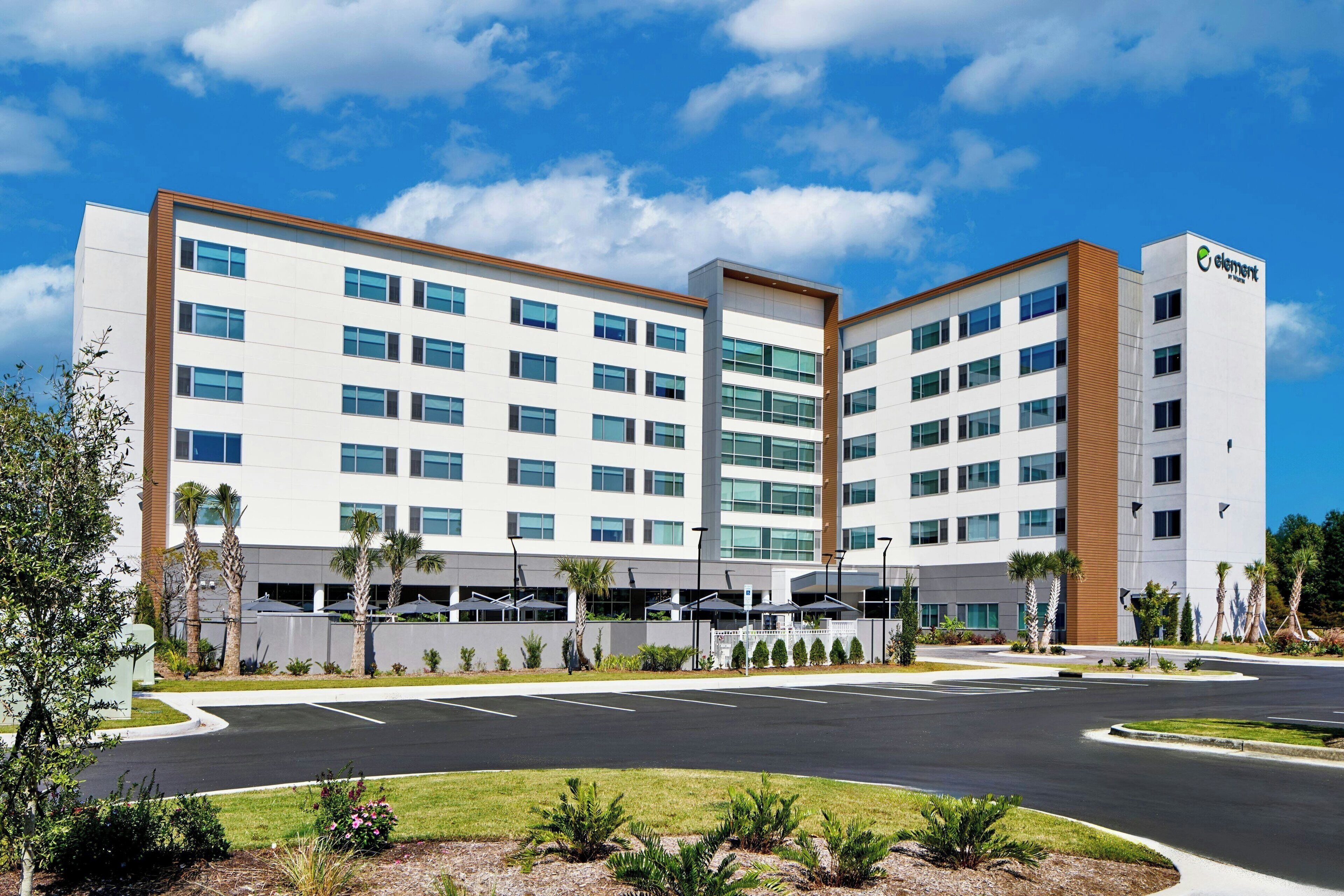 A modern hotel with a central courtyard, multiple floors, and a prominent 'element' sign.