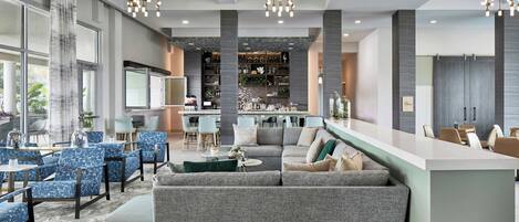 Un espace de détente moderne doté d’un bar, de sièges et d’une grande fenêtre.