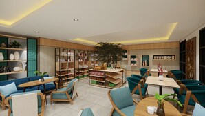 Un intérieur moderne comprenant un coin salon, des étagères et une plante d’ornement placée au centre.