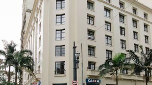 A multi-story building with a beige facade, multiple windows, and a storefront with a blue awning. - Jacques Pilon Residence (Centro Histórico de São Paulo São Paulo)