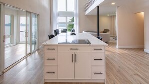 A modern kitchen with a large island, sliding glass doors, and a view of the outdoors.