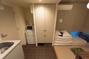 A compact room with a kitchenette, a wardrobe, a bed with pillows, and a small table. - Fare Metallo Hotel Tatami room 401- with AC, WiFi,bath in Nakano, Near Shinjyuku (Nakano City)