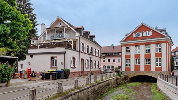 Kanavan varrella sijaitseva rakennus, jossa on silta, ravintola ja autotalli.