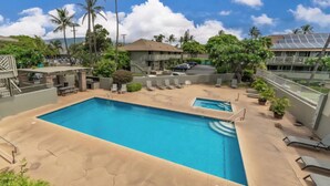 A pool area with lounge chairs, a small pool, and palm trees. - Charming Studio condo in peaceful Kihei with AC, WiFi, pool (Kihei)
