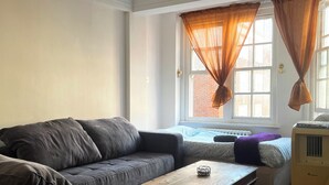 A living room with a grey sofa, a wooden coffee table, and a radiator.