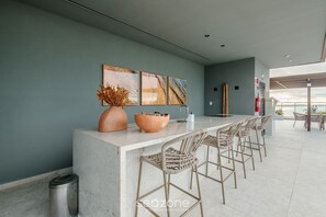 A modern kitchen with a bar area, a trash bin, and a view of the outdoors. - Stay With Style and Convenience in Salvador LIV (Salvador)