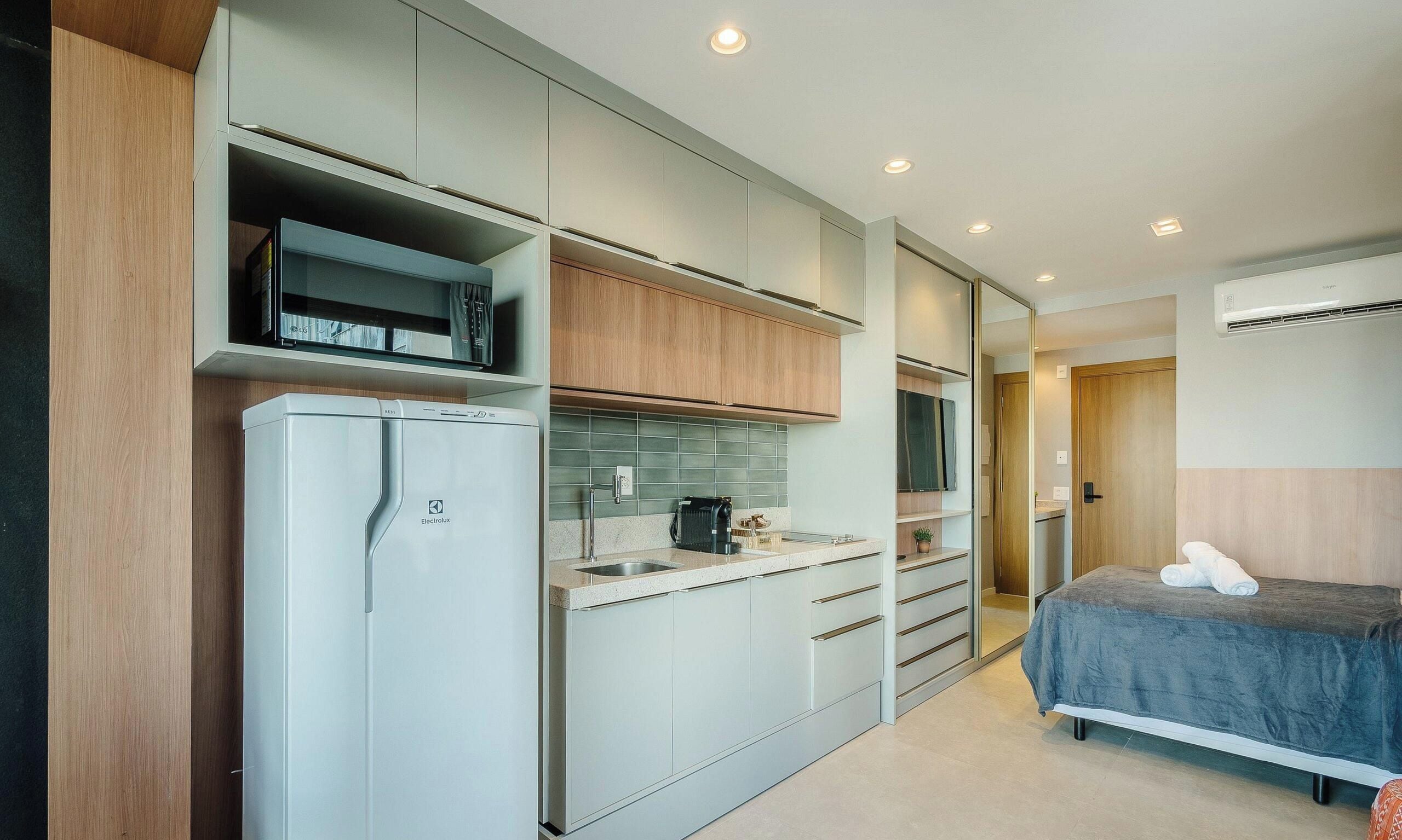 A compact kitchenette with a refrigerator, microwave, and a coffee maker.